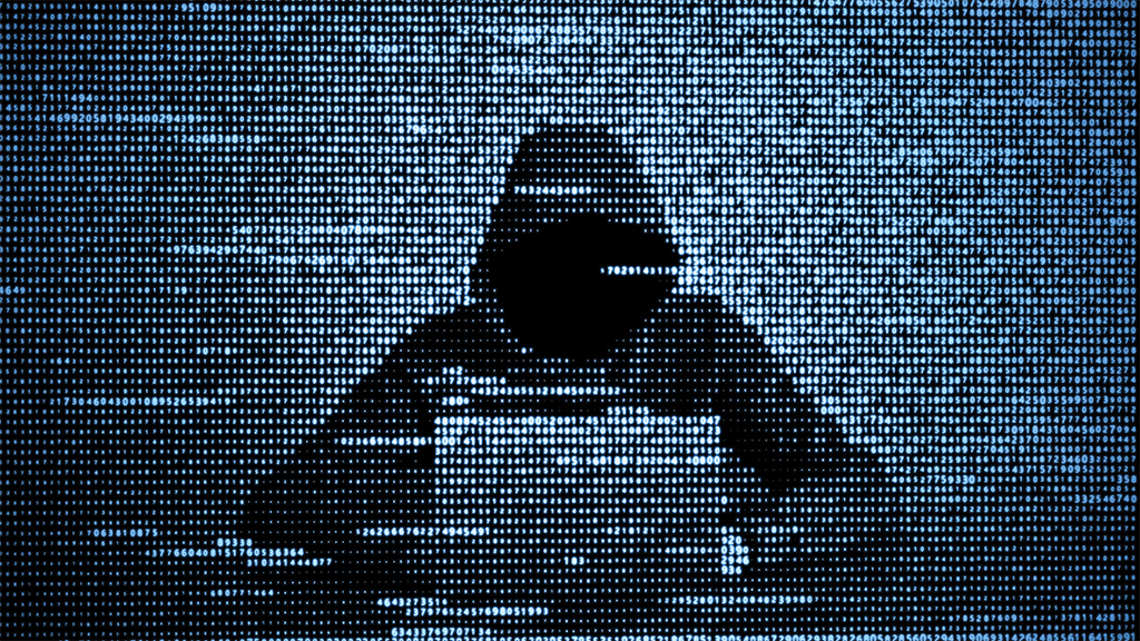 An image of a hacker wearing a sweatshirt that obscures his face