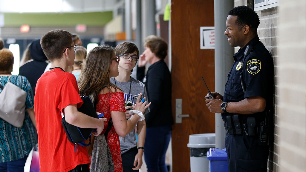 students talking with a school resource officer