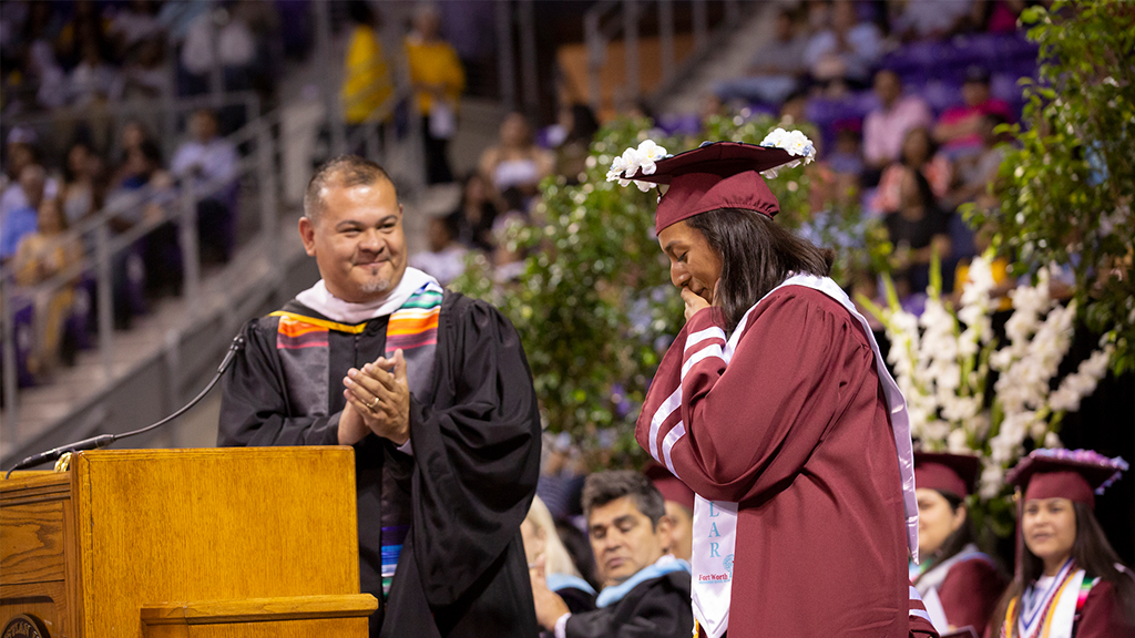 Jacinto Ramos on stage with a student graduating