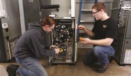 two students work on a machine