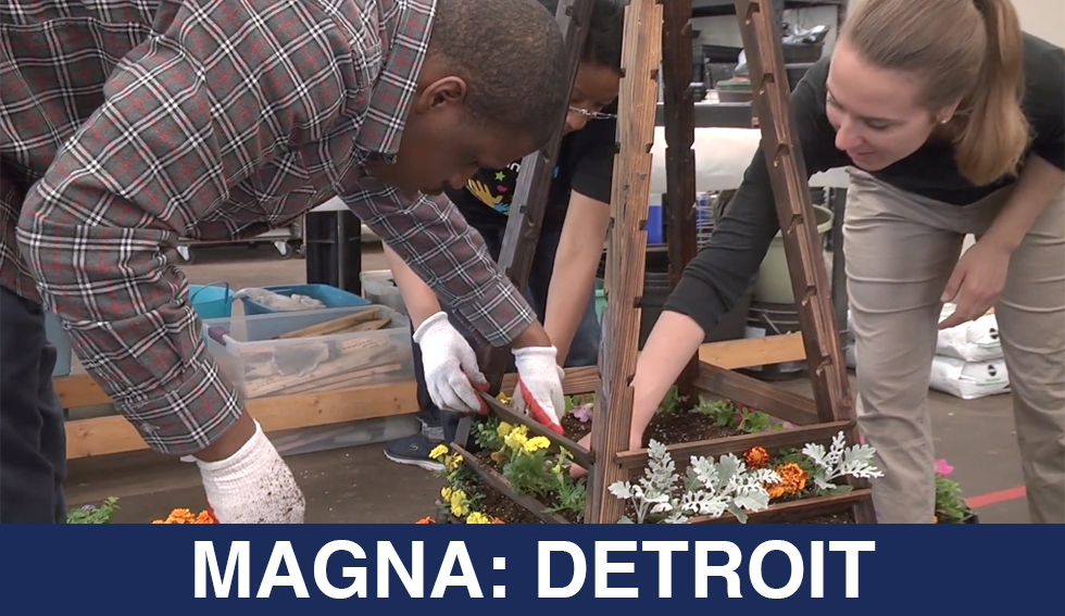students plant flowers. the text reads "Magna: Detroit"