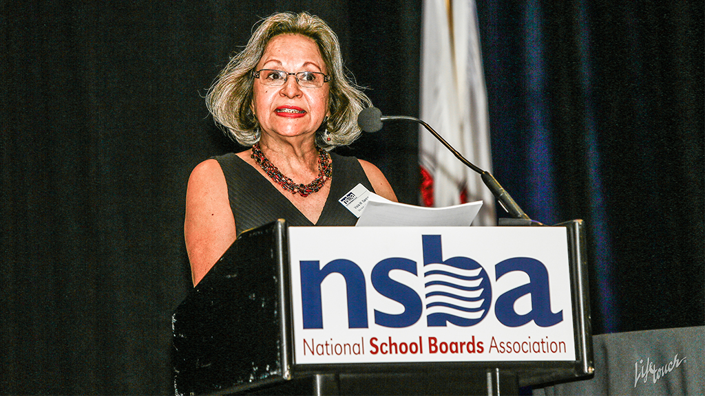 Viola Garcia speaks at a podium at an NSBA event