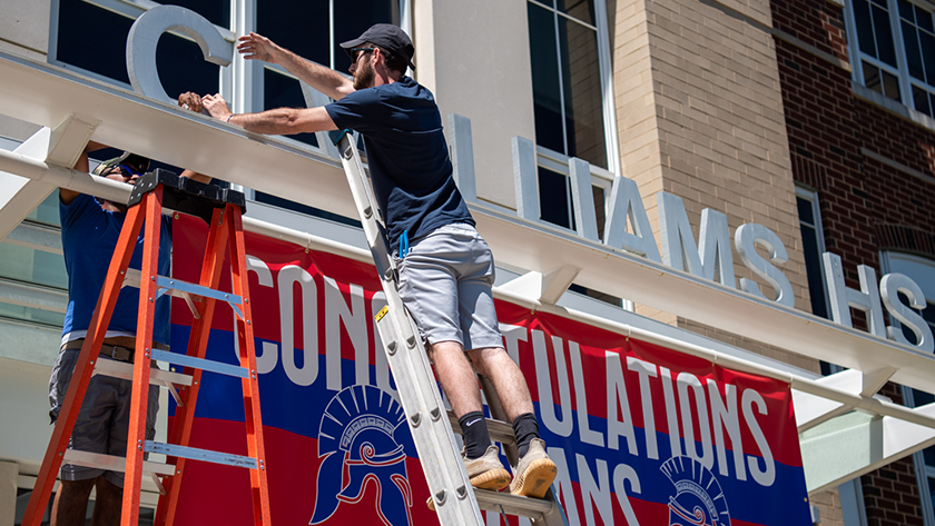 Workman removes signage from school building
