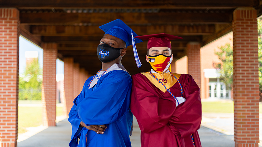 Two graduates dressed in their caps and gowns