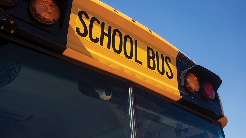 The words school bus are visible on top of a yellow school bus.