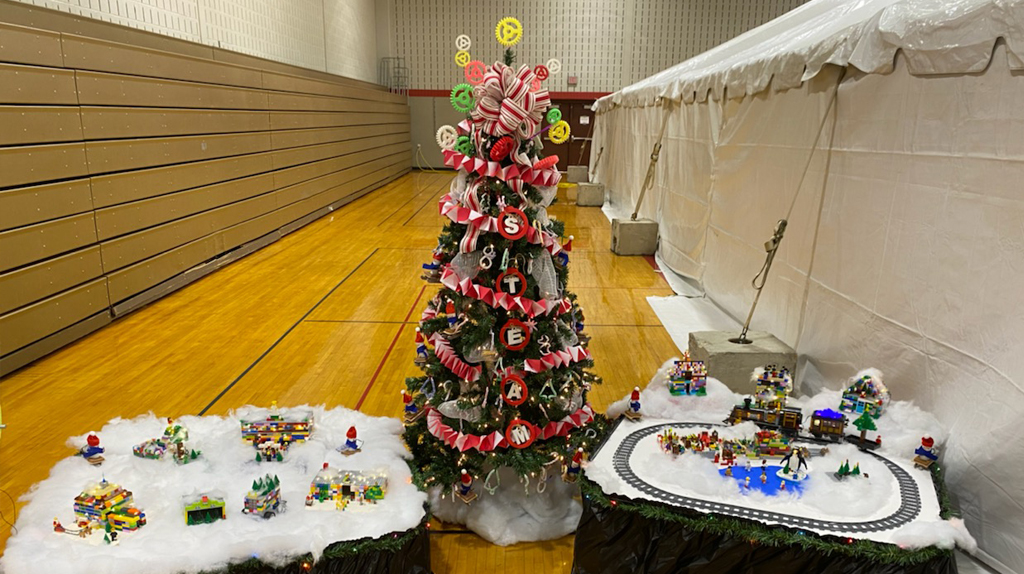 A decorated Christmas tree and village scene designed by students