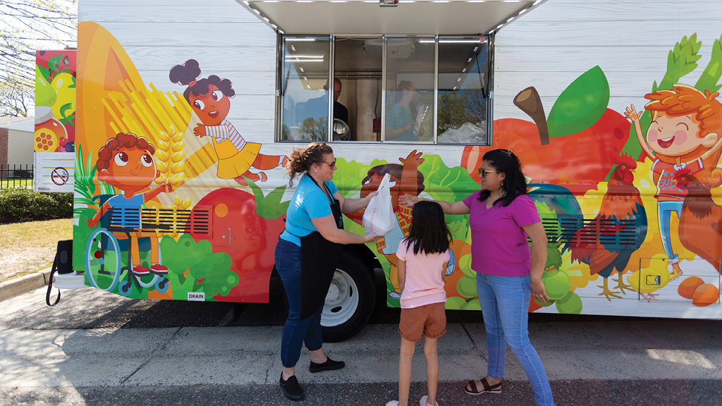 A school food truck delivers lunch to a student. 