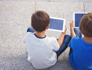 two young students use tablets outside