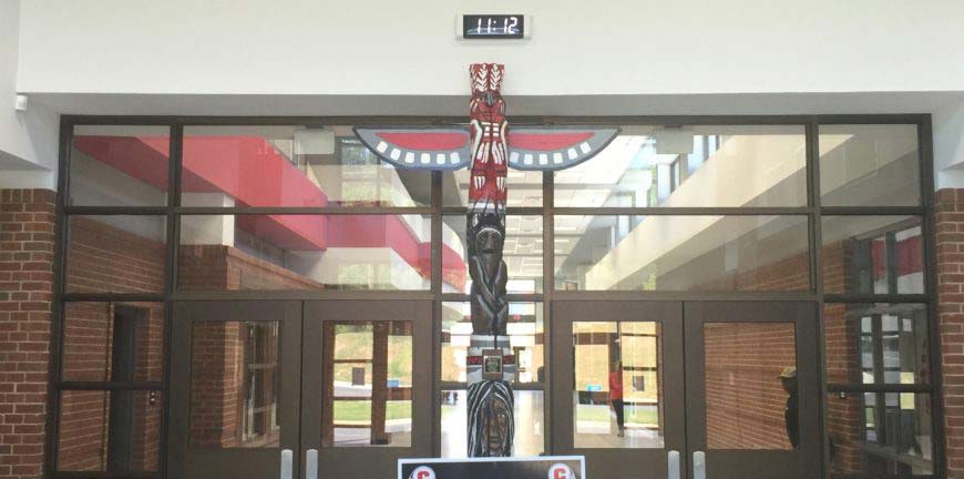 A totem pole display inside a high school